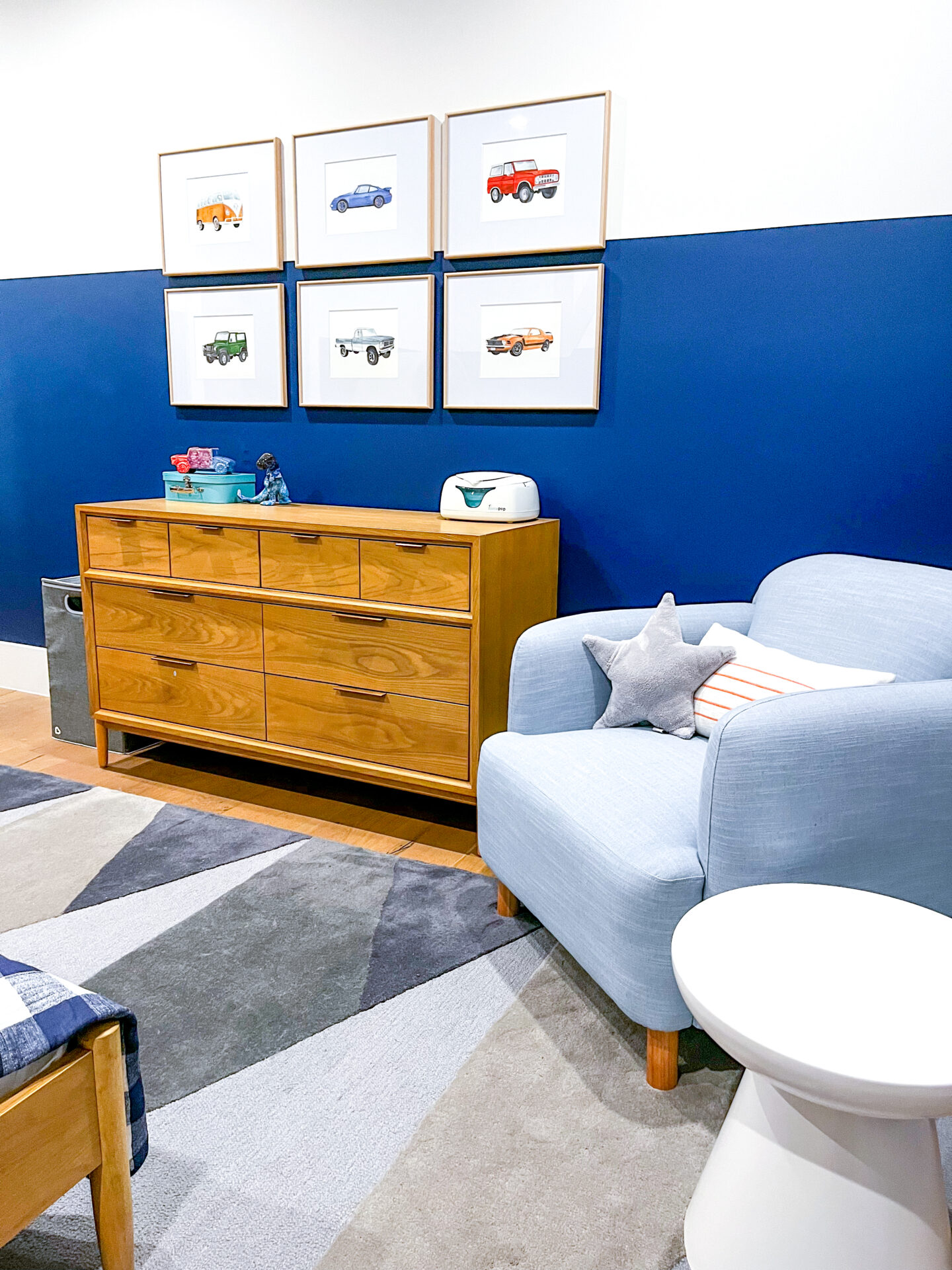 A blue room with two chairs and a dresser