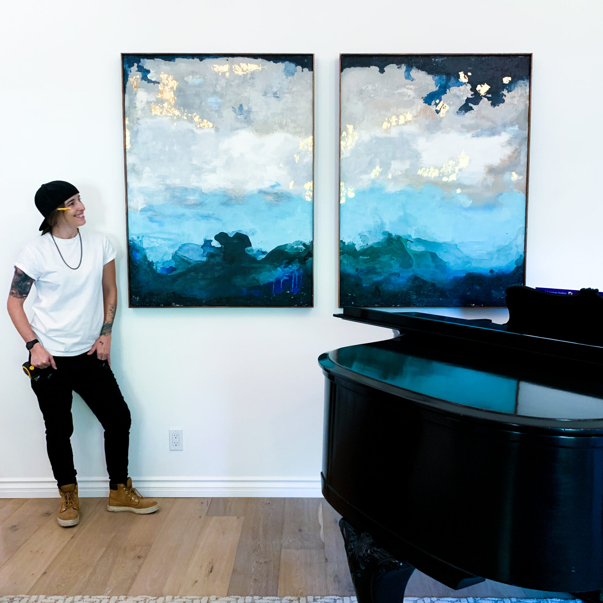 A man sitting in front of two paintings.