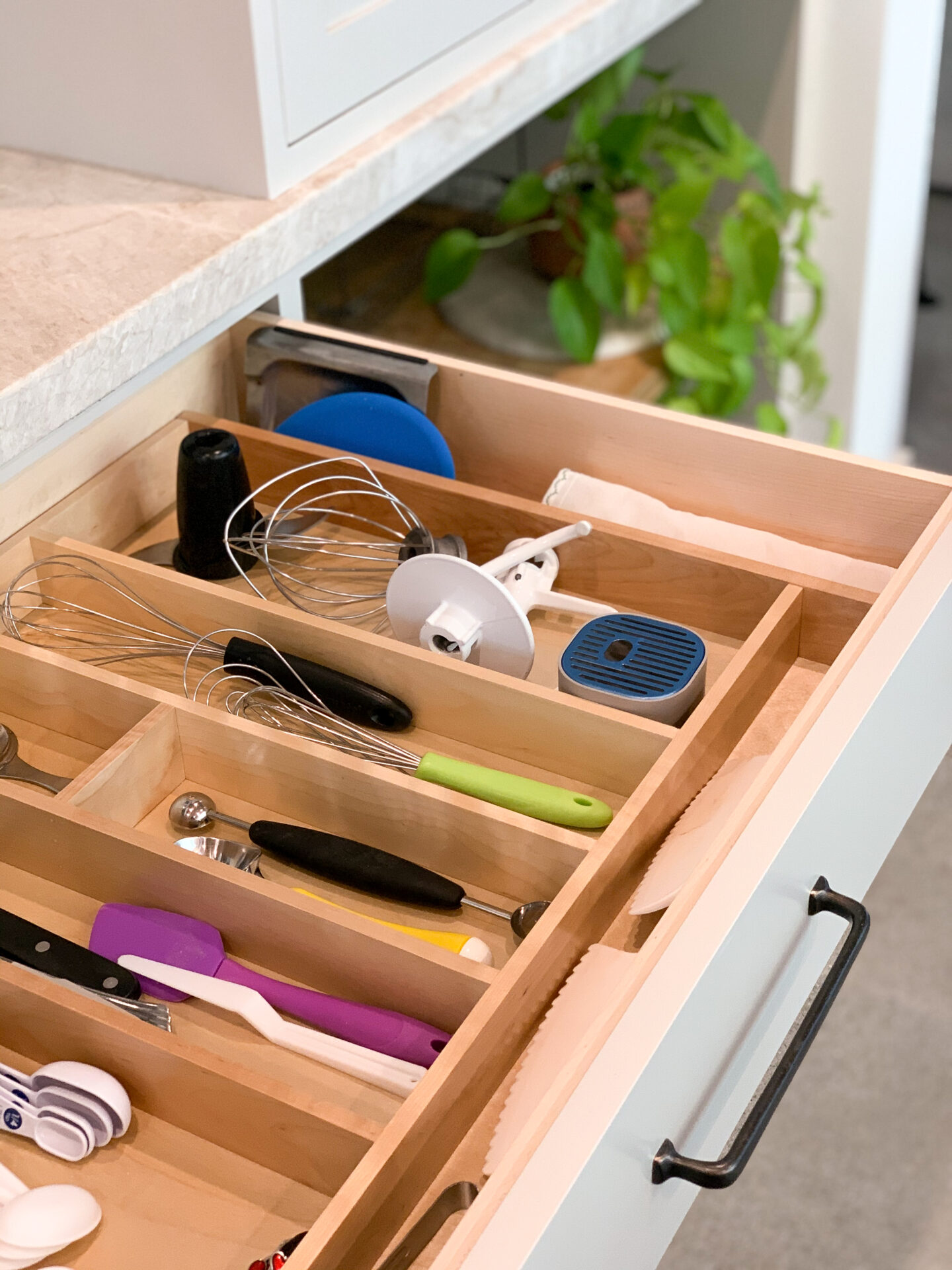 A wooden drawer with many different items in it.