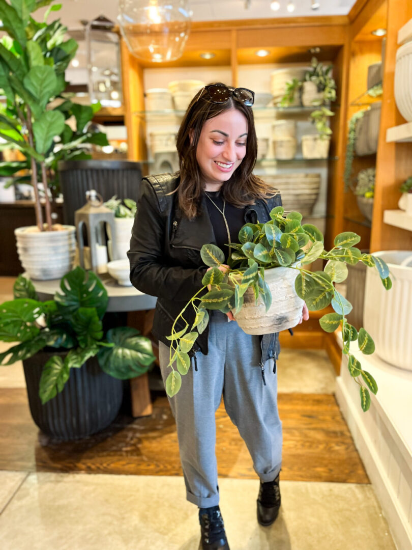 A woman holding a plant in her hands.